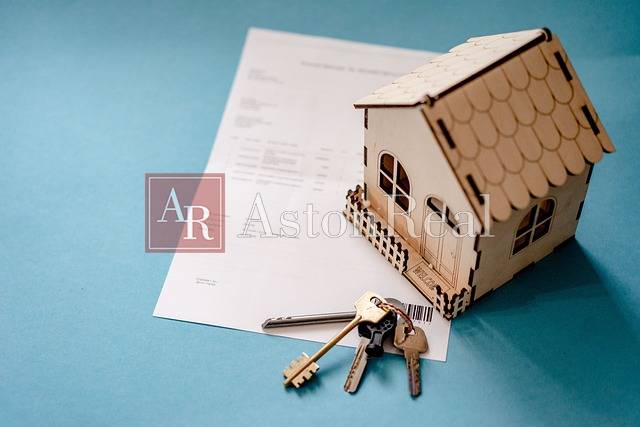 Keys to a 3-room apartment and a model house placed on a blue background.