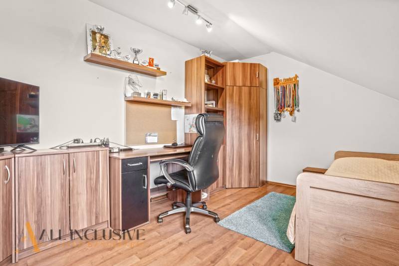 Office in a family house with wooden decor, trophies, and a desk.