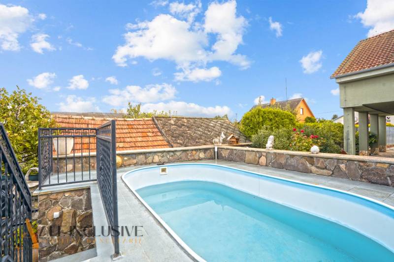 Swimming pool and stone fence at the family house on Kúpeľná Street in Dunajská Streda.