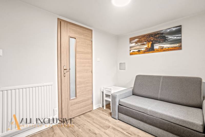 Living room in a family house with a sofa, table, and wooden decor flooring.