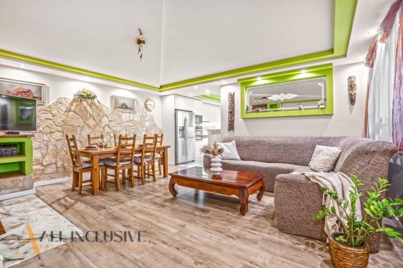 A living room in a family house with a stone wall and a wooden decor floor.