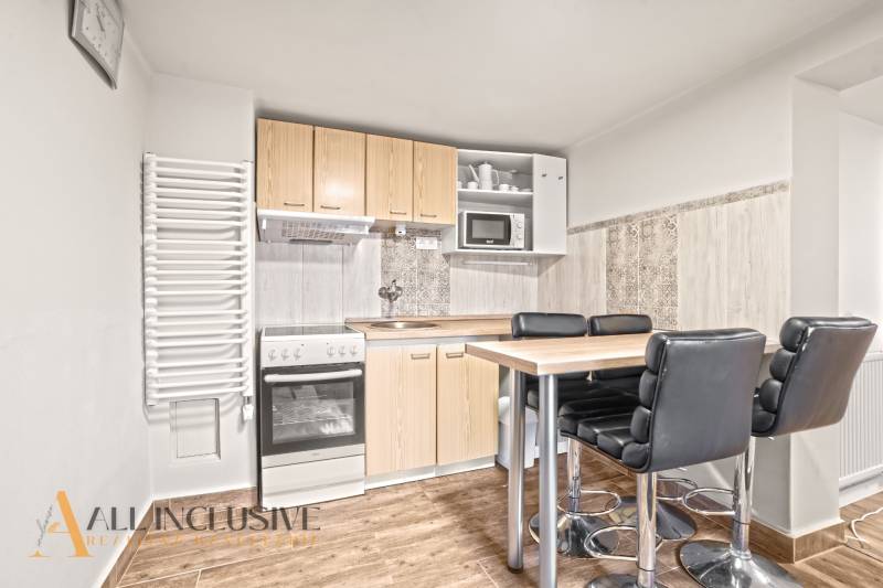 A kitchen in a family house with a countertop, chairs, and a floor with a wooden decor.