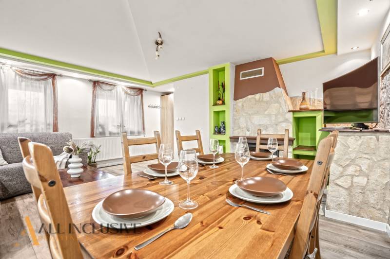 Dining room in a family house with a wooden table, glasses, and a decorative fireplace.