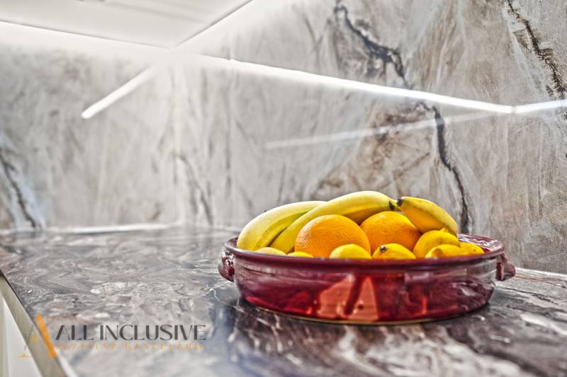 A fruit bowl on a stone kitchen countertop in a family house.