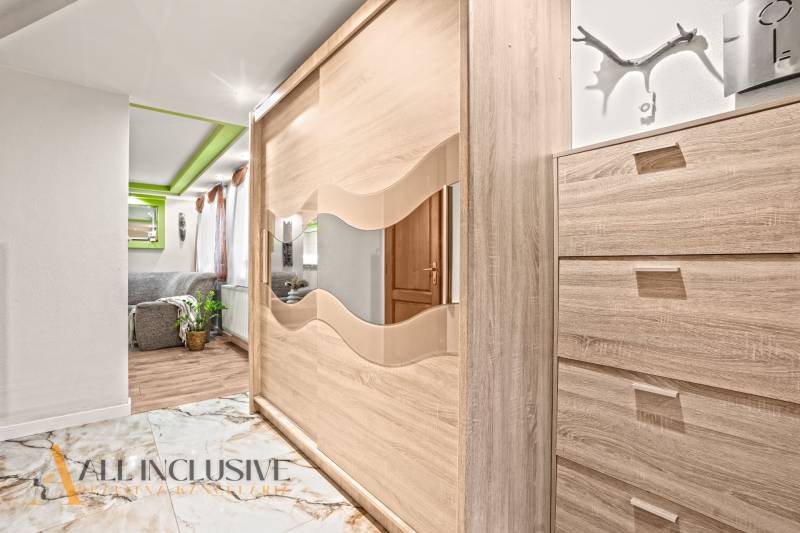 In the family house, you can see a wardrobe with a mirror and a floor with a wooden decor.