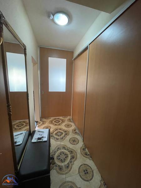 In the hallway of the one-room apartment, there is a mirror, a wardrobe, and patterned tiles.