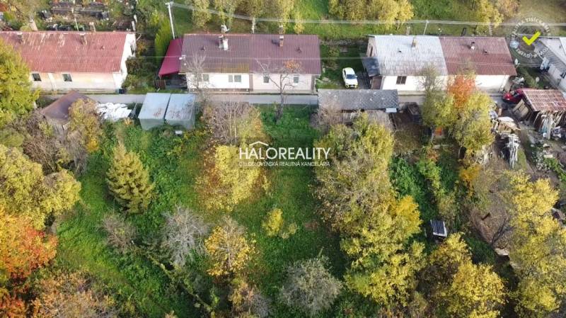 A family house in Sirk, surrounded by greenery and trees, with single-story buildings.