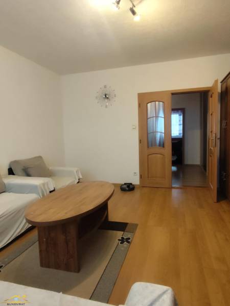 Living room with wood-patterned flooring, a coffee table, and two sofas, 3-room apartment.