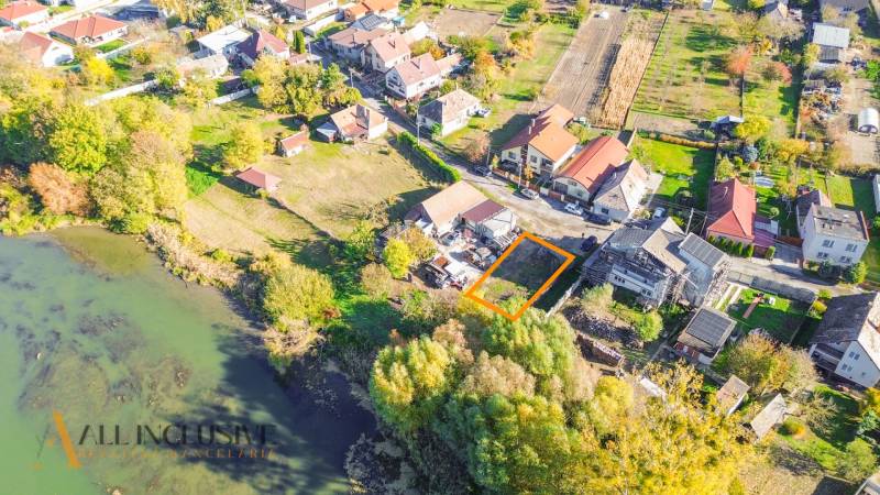 Aerial photograph of residential plots in Jahodná near a body of water surrounded by greenery.