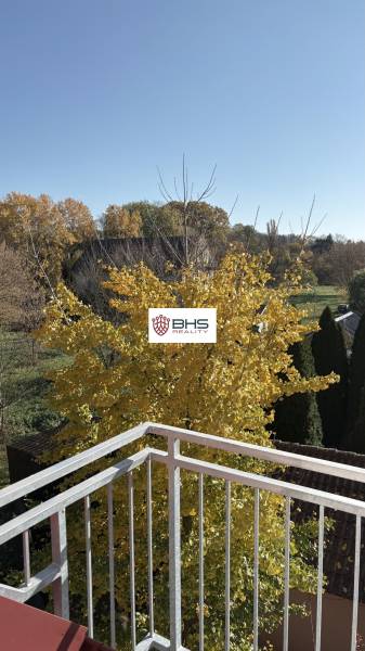 A balcony in a 3-room apartment in Tomášikovo with a view of the autumn landscape and a tree.