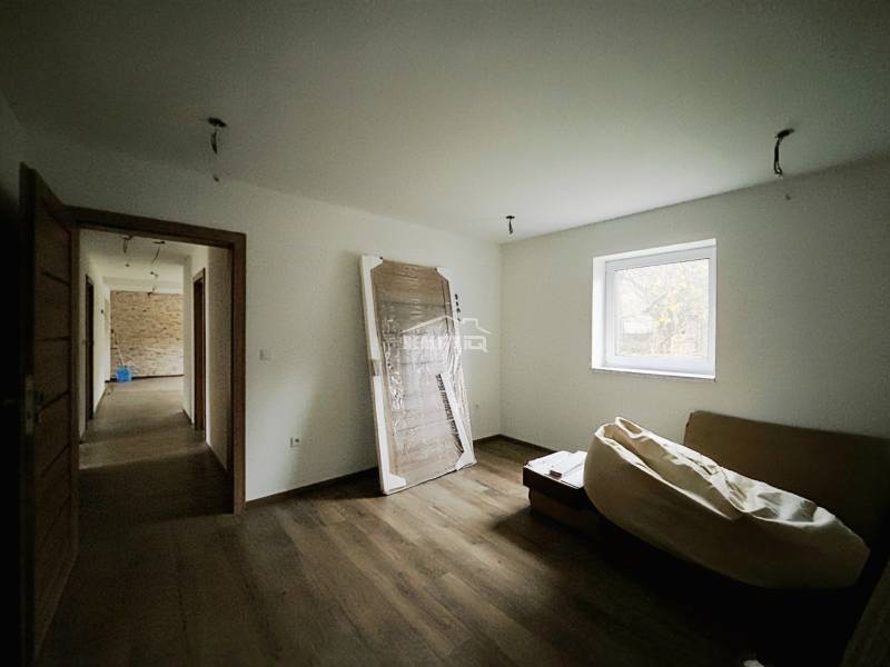 A room in a family house with a wooden decor floor and simple furnishings.