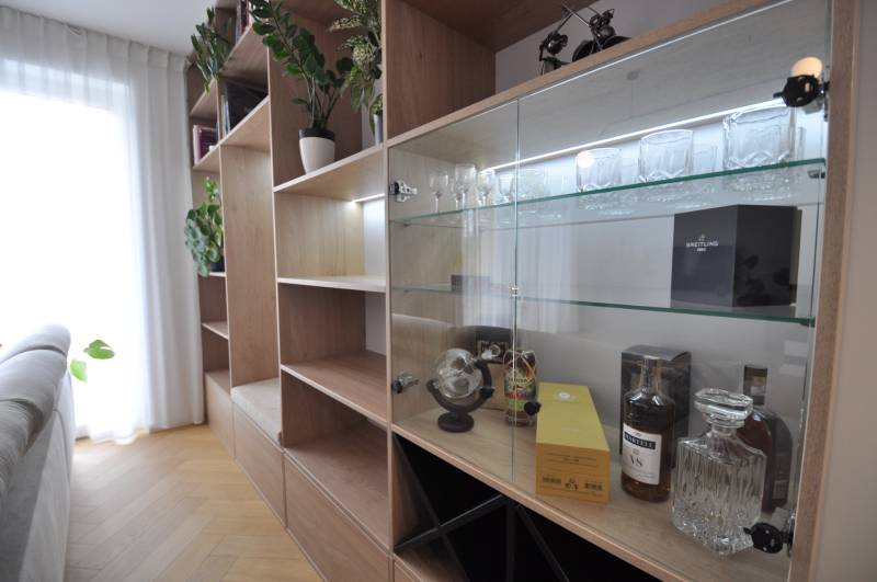 Interior of a family house with a wardrobe, glass shelves, and a floor with a wooden decor.