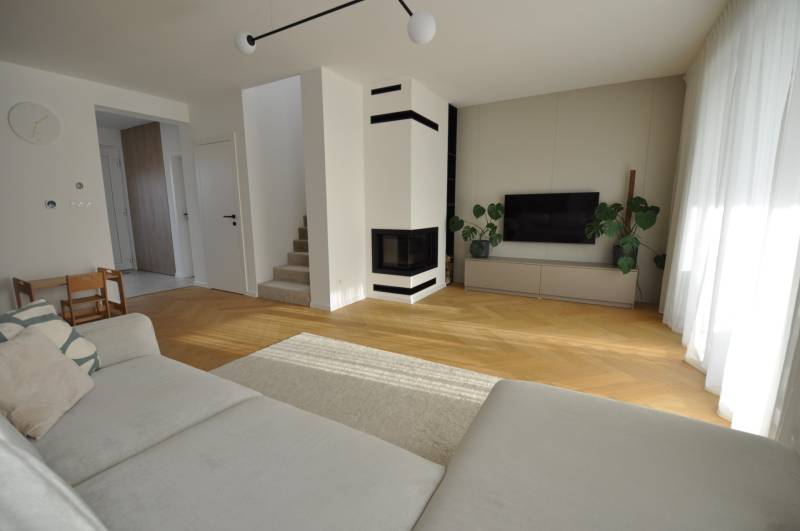 Living room in a family house with a fireplace and a wooden decor floor.