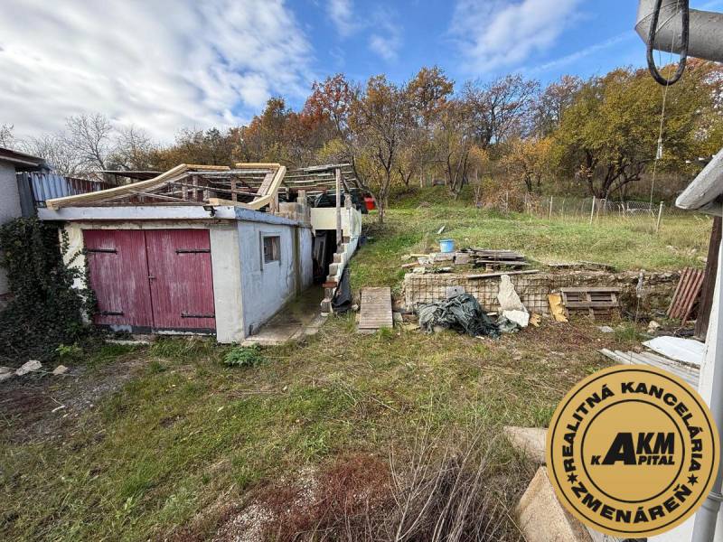 A family house in Stará Kremnička with an unmaintained garden, an old garage, and a wooden structure.