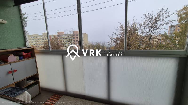 A glazed balcony in a 3-room apartment with a view of apartment buildings and trees.