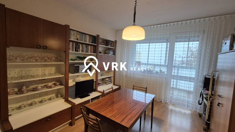Dining area with a bookshelf and a glass cabinet in a 3-room apartment.