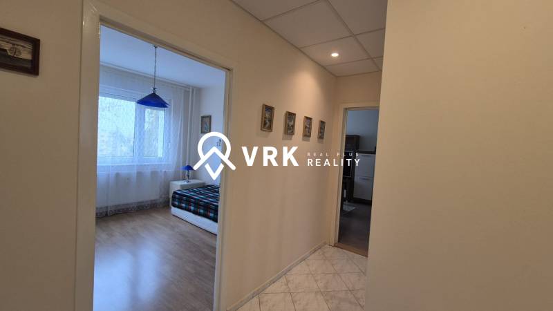 The hallway leading to the bedroom in a 3-room apartment with a wooden decor floor.
