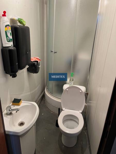 A small bathroom with a shower, sink, and toilet in warehouses and halls.