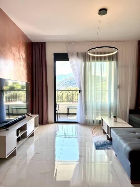 Living room in a studio apartment with marble flooring and a mountain view.
