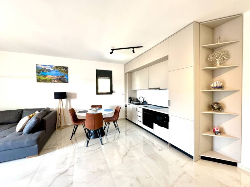 Bright kitchen with a dining table and a comfortable sofa in a studio apartment.