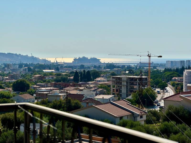 A view of the city of Bar with a sea view and construction cranes.
