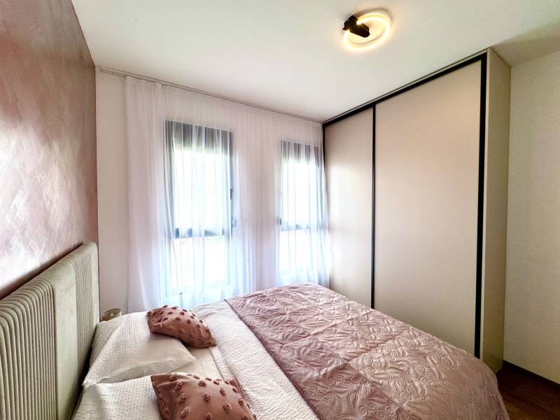 A room with light furniture and decorative pillows in a studio apartment.