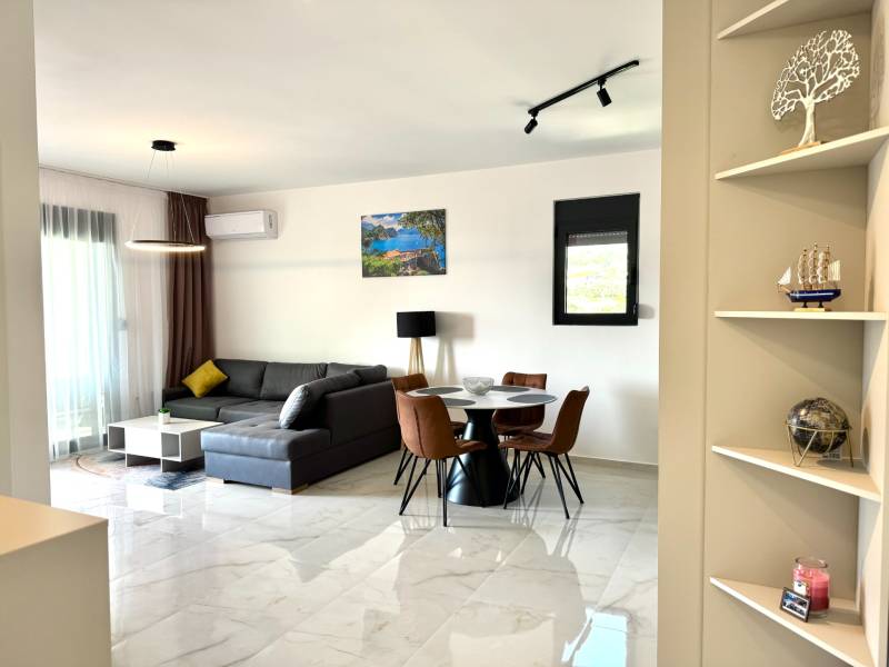 Living room with a comfortable corner sofa and a dining table in a studio apartment.