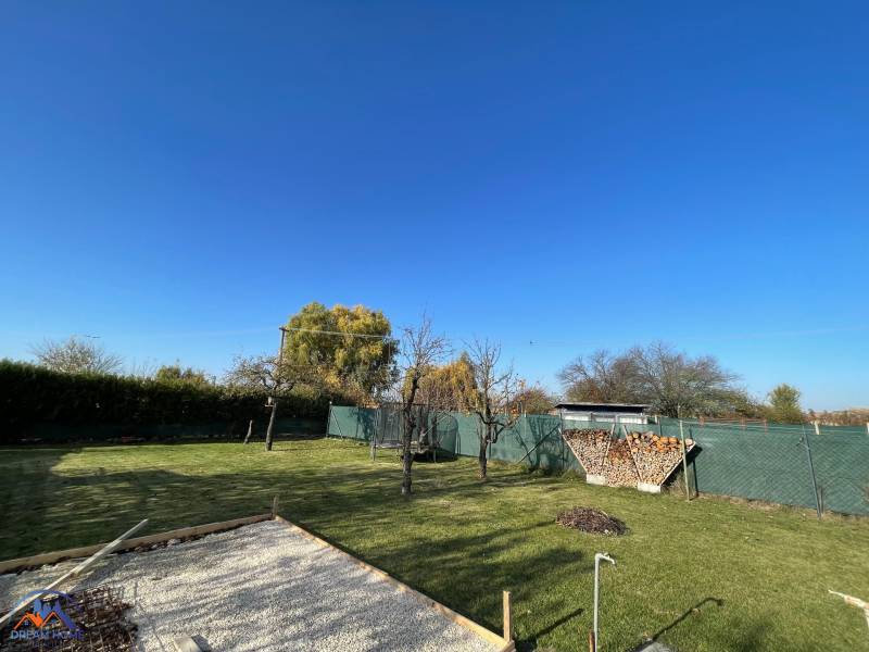 A garden by the cottage in Nova Osada in Komárno with a lawn and a fireplace.