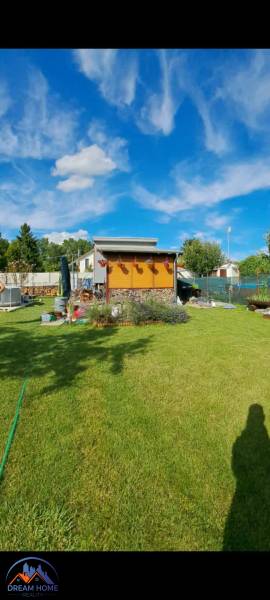 A garden at the cottage in Nova Osada in Komárno with a blue sky and a manicured lawn.