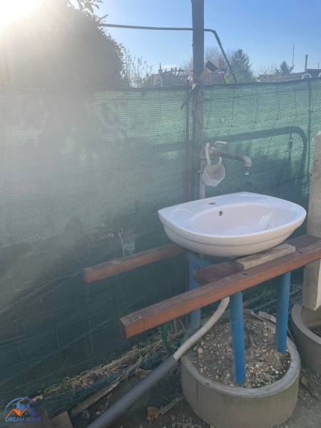 A sink at the cottage in Nova Osada in Komárno, outdoors with protective mesh.