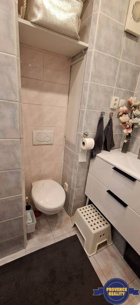 Bathroom in a 3-room apartment with a toilet, sink, and decorative accessories.
