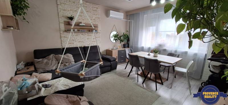 Living room in a 3-room apartment with a sofa, swing, and dining table.