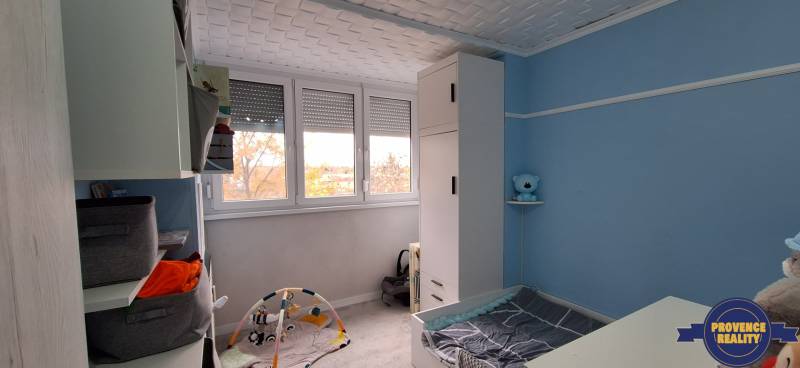 Children's room with blue walls, white cabinets, and a children's play mat.