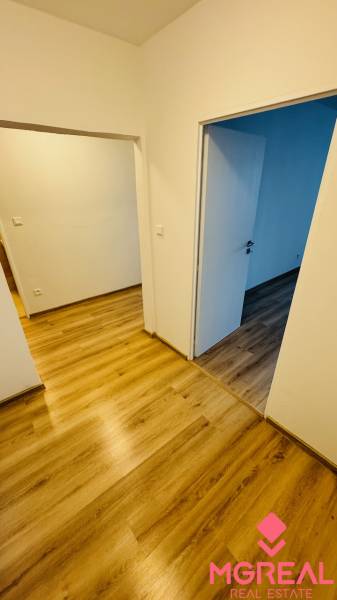 An interior with white walls and a wooden decor floor in a studio apartment.