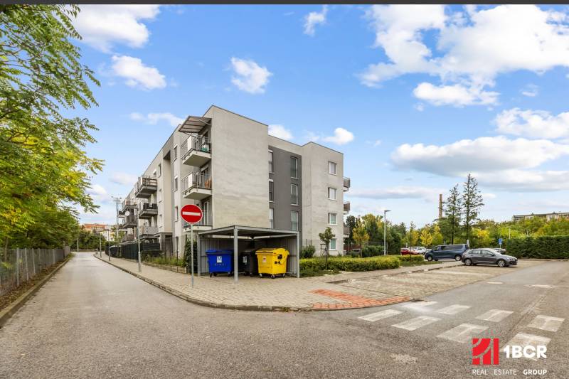 Apartment building on Mahulanka Street in Pezinok with a parking lot and containers.