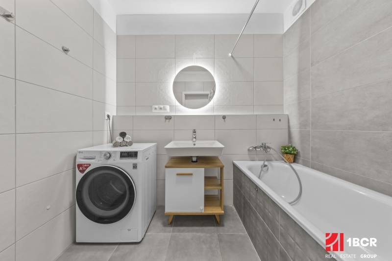Bathroom with a washing machine, sink, and bathtub, 2-room apartment.