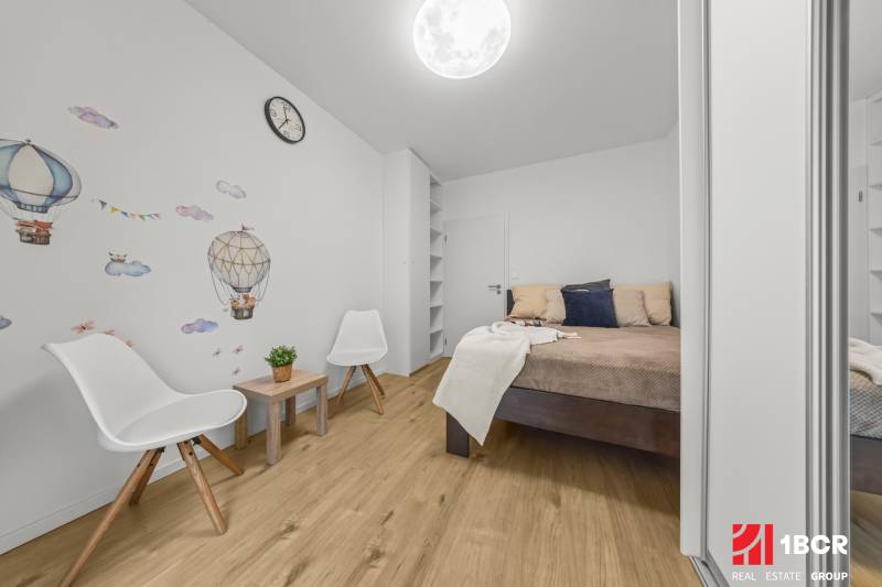 A bedroom in a two-room apartment with wall decor and a wooden floor decor.
