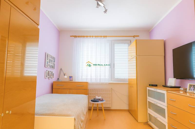 Bright bedroom in a two-room apartment with a drawer chest and a built-in wardrobe.