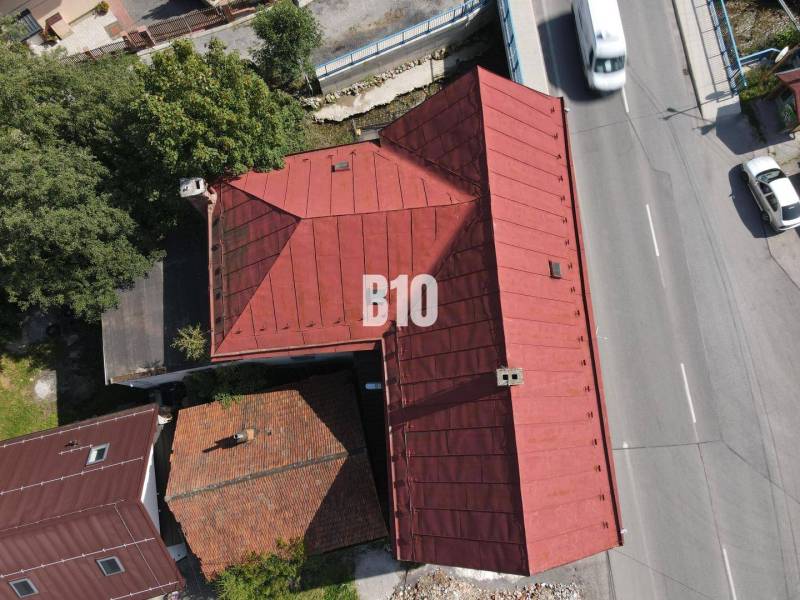 The roof of a building in Belá and a road with cars from a bird's-eye view.