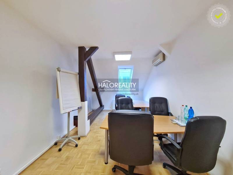 Offices with wooden decor flooring, desk, chairs, flipchart, water on the table.