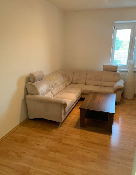 Living room with a comfortable sofa and a table on a floor with a wooden decor.