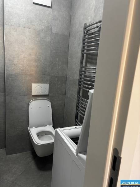 Bathroom with tiles, washing machine, and toilet in a 2-room apartment.
