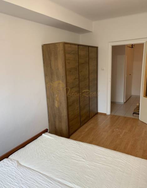 Bedroom in a 2-room apartment with a wooden decor floor and a wardrobe.