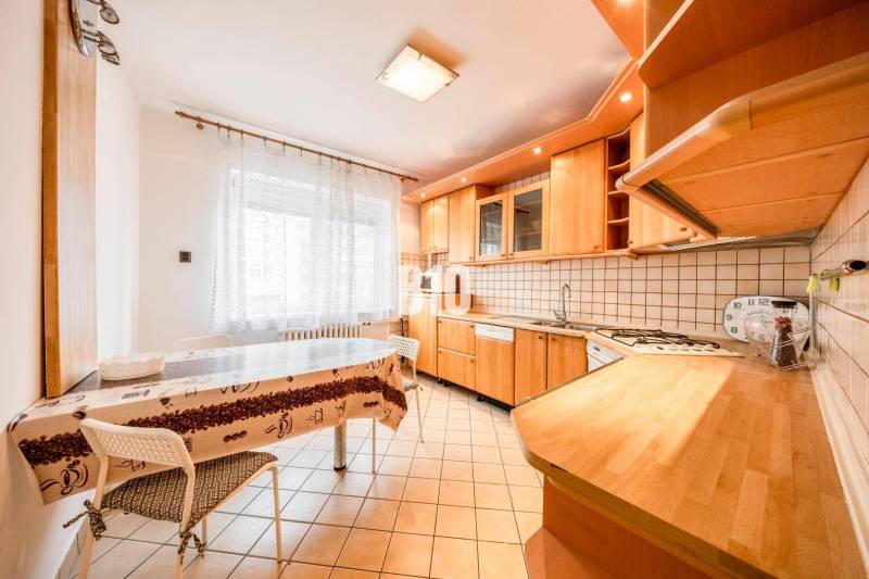 A kitchen in a 4-room apartment with light seating and wooden decor equipment.