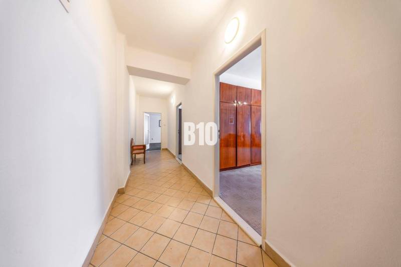 A hallway with tiles and an entrance to a room in a 4-room apartment.