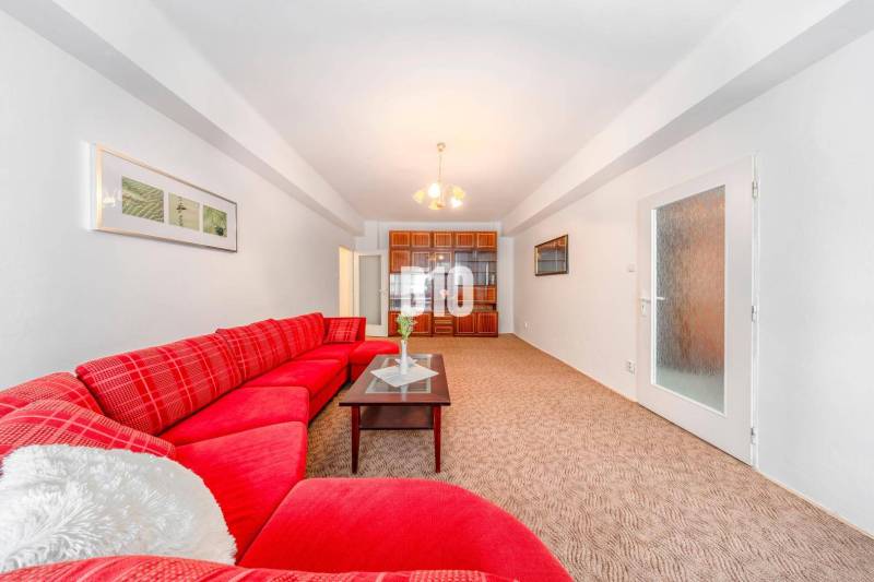 Red sofa, glass table, built-in cabinet, and light carpet in a 4-room apartment.