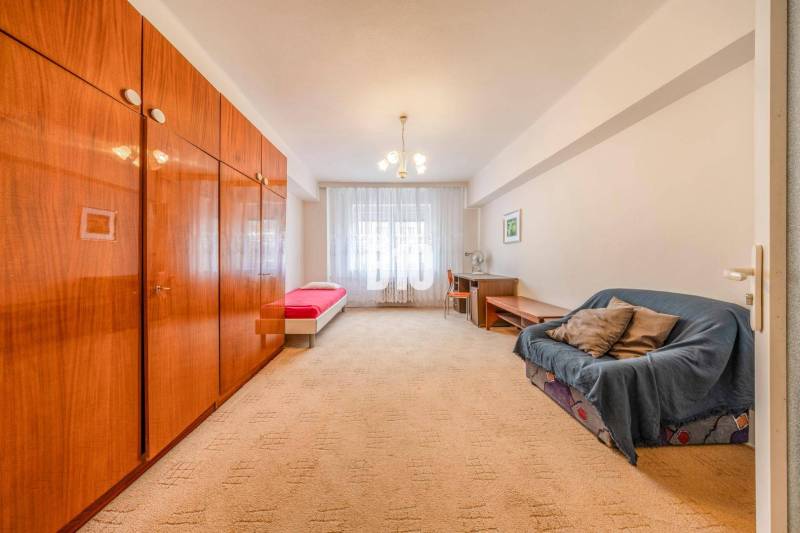 A room in a 4-room apartment with a large wardrobe, a sofa, and a single bed.
