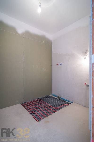 A room under construction in a 2-room apartment with wiring on the floor.
