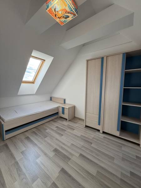 Children's room with a skylight, bed, and wardrobe in a 4-room apartment.