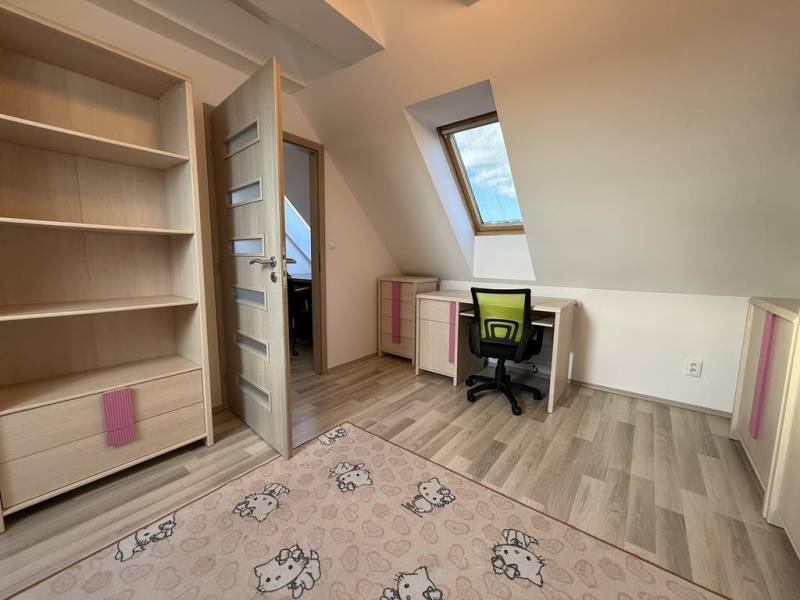 A room in a 4-room apartment with a wooden decor floor and an office corner.